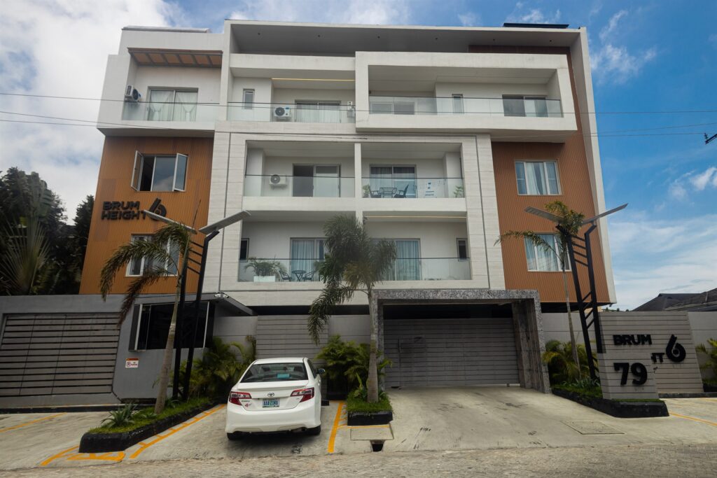 Brum Height 6: Front exterior with glazed balconies, planted frontage and parking